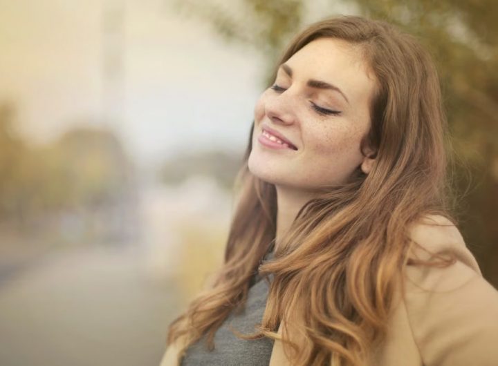 Portrait of a woman with closed eyes, enjoying the outdoors in autumn. Bright and serene.